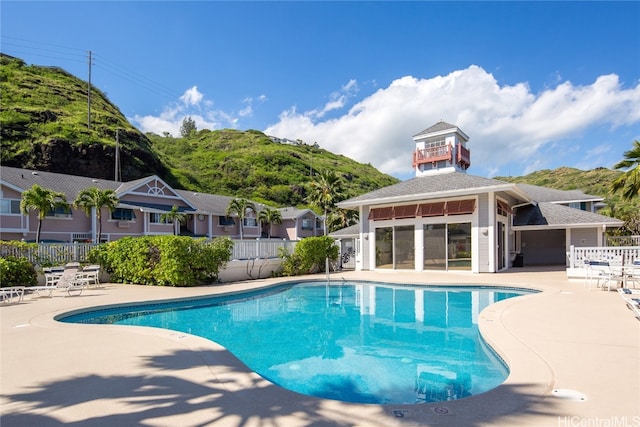 view of swimming pool featuring a patio and a mountain view