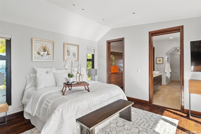 bedroom with dark hardwood / wood-style flooring, connected bathroom, and lofted ceiling