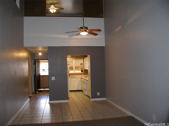 interior space with ceiling fan, sink, and light tile patterned floors