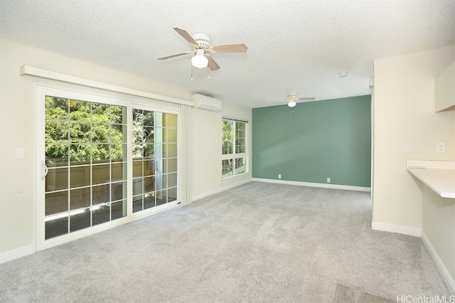 interior space with light carpet, a wall unit AC, a textured ceiling, and ceiling fan