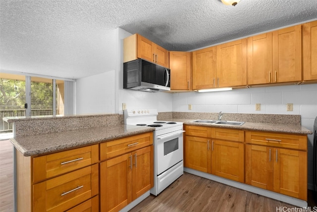 kitchen featuring kitchen peninsula, electric range, backsplash, wood-type flooring, and sink