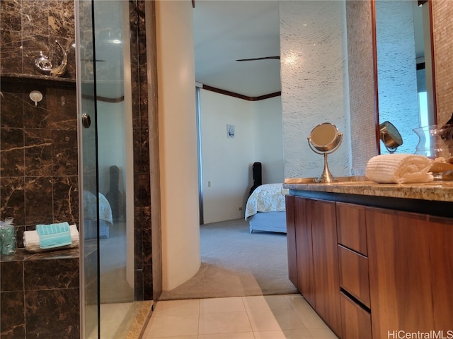 bathroom featuring vanity, ornamental molding, a shower with shower door, and tile patterned floors