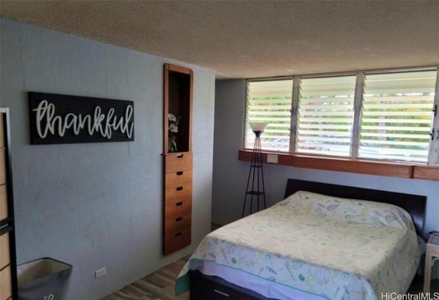 bedroom with hardwood / wood-style flooring and a textured ceiling