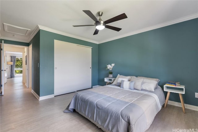 bedroom with crown molding, wood-type flooring, a closet, and ceiling fan