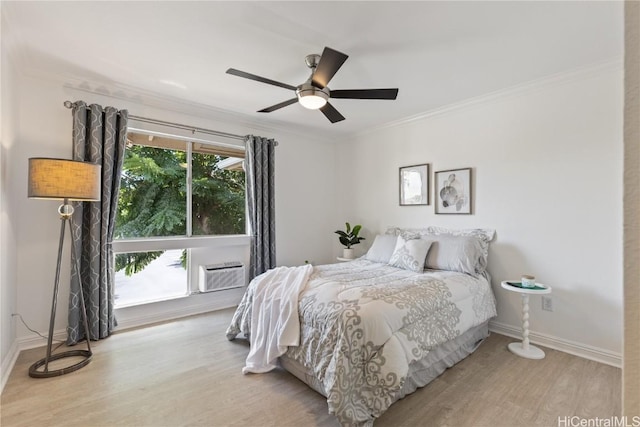 bedroom featuring ceiling fan, ornamental molding, light hardwood / wood-style floors, and an AC wall unit