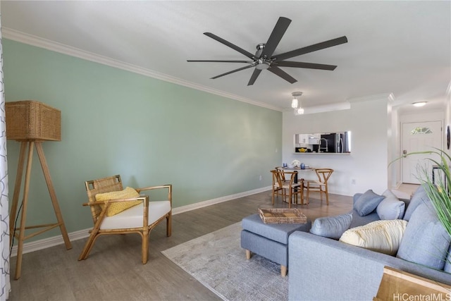 living room with hardwood / wood-style flooring, ceiling fan, and ornamental molding