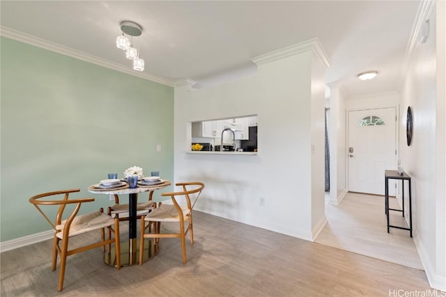 dining room with crown molding and light hardwood / wood-style flooring