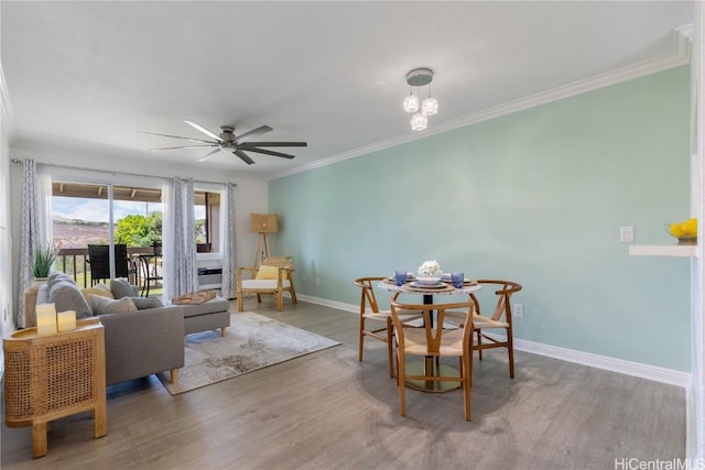 living room featuring crown molding, wood-type flooring, and ceiling fan with notable chandelier