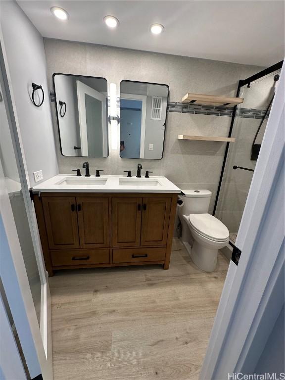 bathroom with vanity, toilet, wood-type flooring, and walk in shower