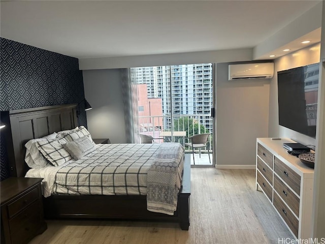 bedroom featuring an AC wall unit and light hardwood / wood-style flooring