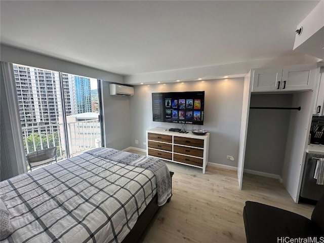 bedroom featuring a wall mounted air conditioner, access to exterior, and light wood-type flooring