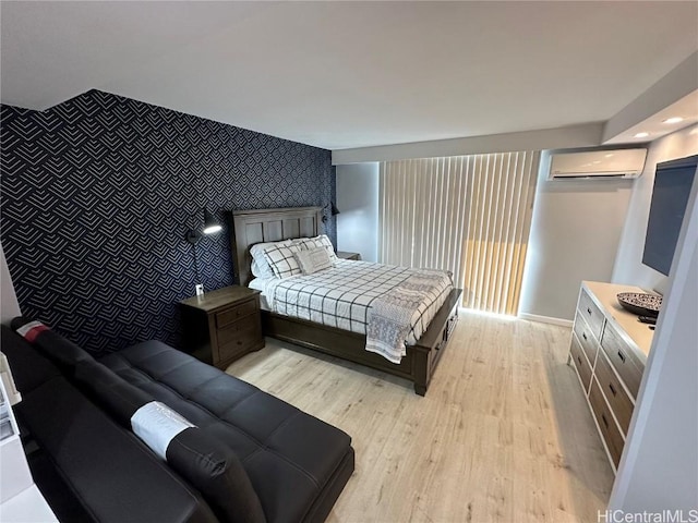 bedroom with a wall mounted air conditioner and light wood-type flooring