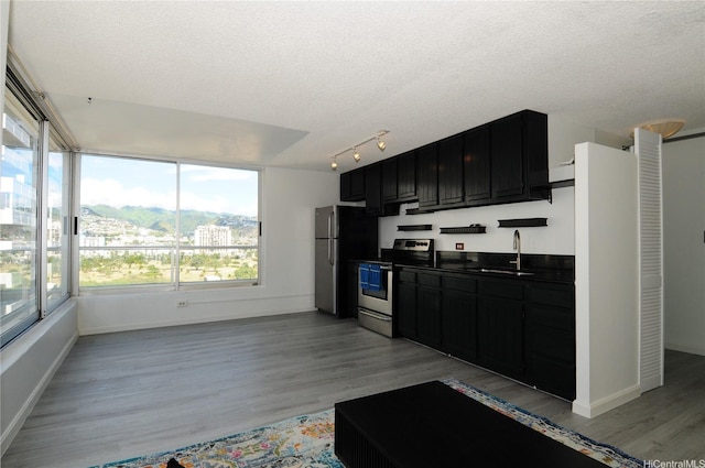 2421 Tusitala St Unit 1402, Honolulu, HI 96815 - kitchen featuring a textured ceiling, appliances with stainless steel finishes, dark cabinetry, and a sink