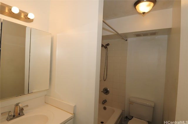 full bathroom featuring vanity, tiled shower / bath combo, and toilet