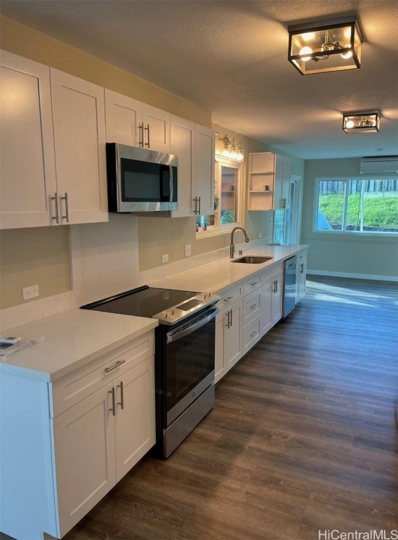 kitchen with dark hardwood / wood-style floors, stainless steel appliances, sink, light stone countertops, and white cabinets