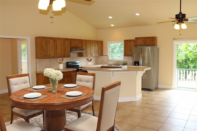 kitchen featuring a kitchen island, backsplash, ceiling fan, light tile patterned flooring, and stainless steel appliances