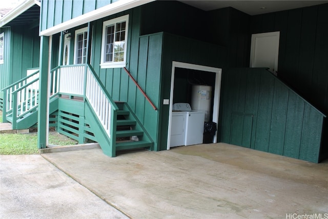 property entrance with electric water heater, a patio, and separate washer and dryer