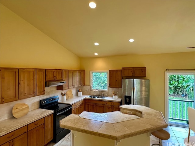 kitchen featuring sink, a kitchen bar, a kitchen island, black / electric stove, and stainless steel fridge with ice dispenser