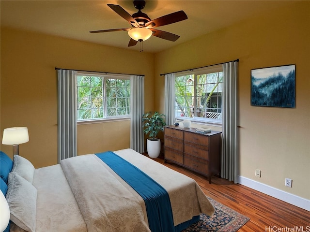 bedroom with multiple windows, light wood-type flooring, and ceiling fan