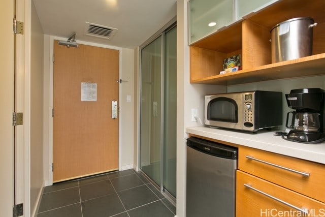 kitchen featuring stainless steel appliances and dark tile patterned floors