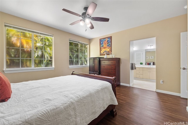 bedroom with ensuite bath, wood finished floors, a ceiling fan, and baseboards