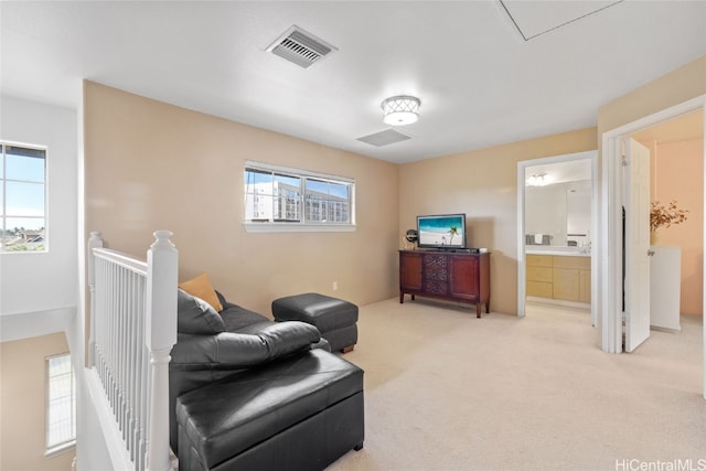 sitting room with light carpet, an upstairs landing, and visible vents