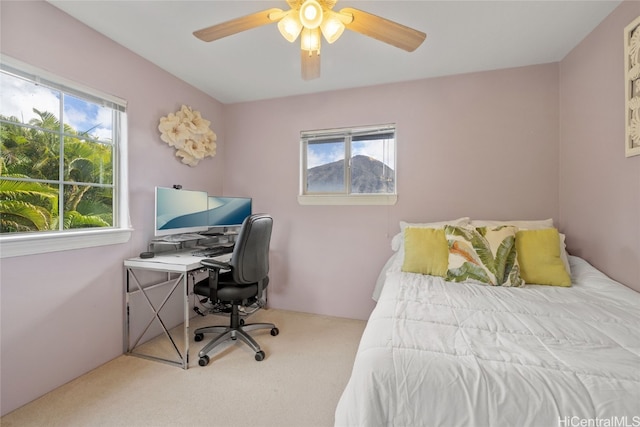 carpeted bedroom featuring multiple windows and ceiling fan