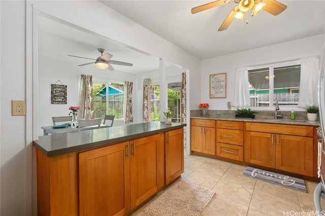 kitchen with ceiling fan, light tile patterned floors, and sink