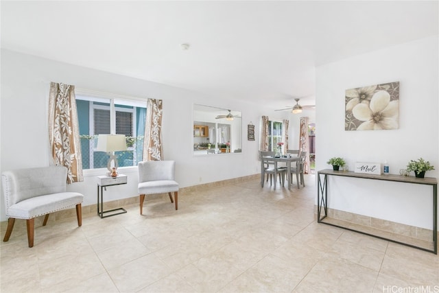 living area with ceiling fan and light tile patterned flooring