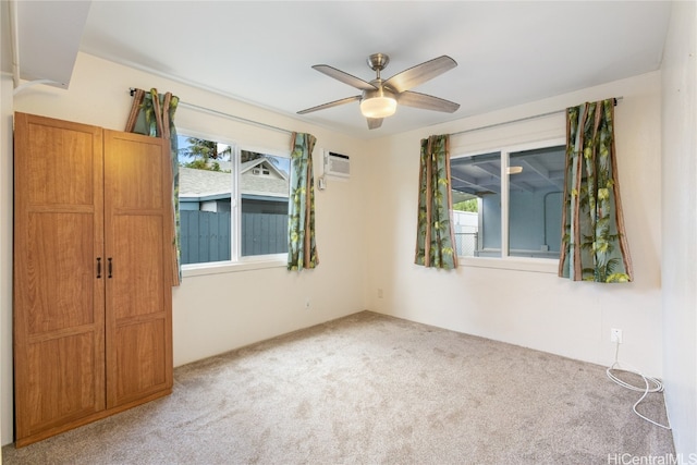 carpeted empty room with an AC wall unit and ceiling fan