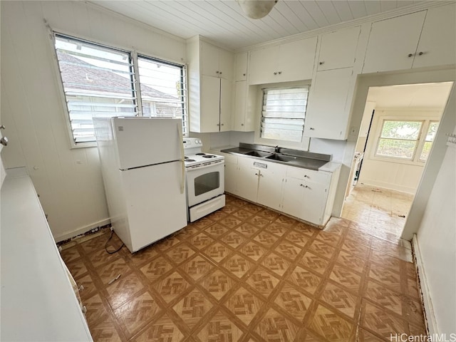 kitchen featuring white appliances, light parquet floors, white cabinetry, and a wealth of natural light