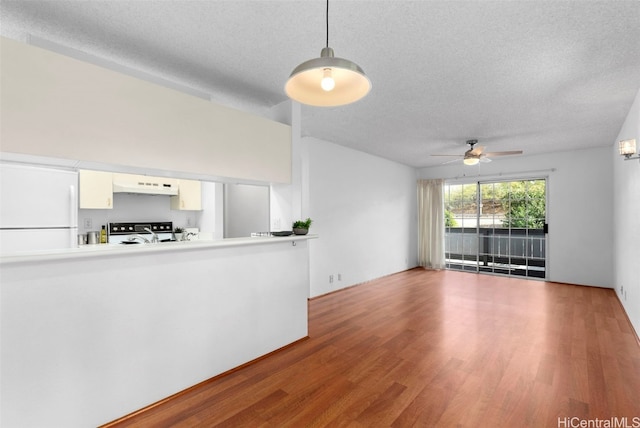 unfurnished living room with ceiling fan, wood-type flooring, and a textured ceiling