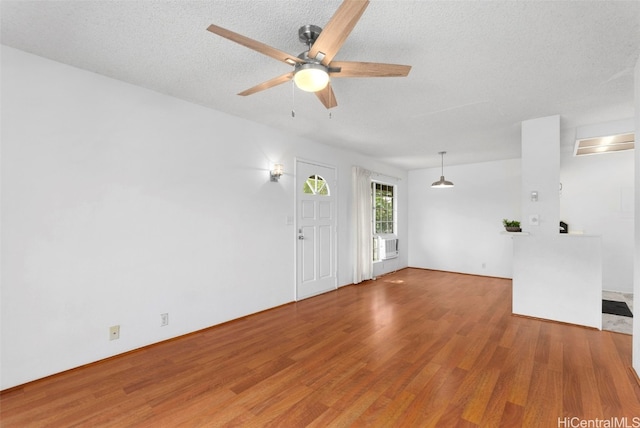 unfurnished living room featuring ceiling fan, a textured ceiling, and hardwood / wood-style floors