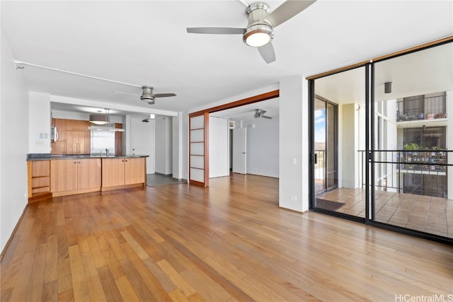 unfurnished living room with light hardwood / wood-style floors and sink