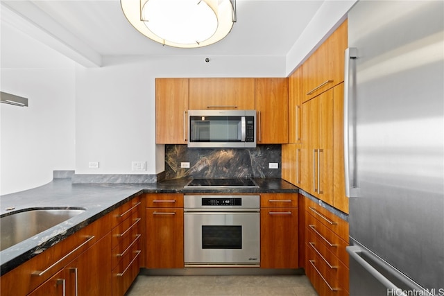 kitchen featuring light tile patterned floors, stainless steel appliances, decorative backsplash, and dark stone counters