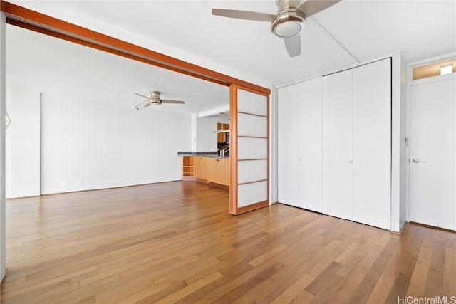 unfurnished living room featuring ceiling fan and light hardwood / wood-style flooring