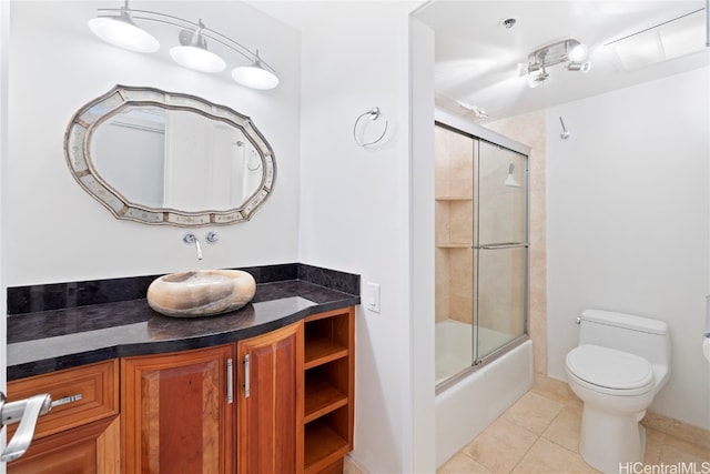 full bathroom featuring vanity, enclosed tub / shower combo, toilet, and tile patterned floors