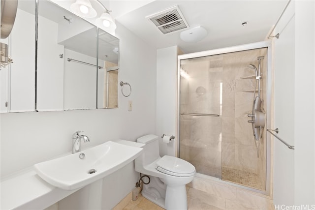 bathroom featuring sink, toilet, tile patterned floors, and a shower with shower door