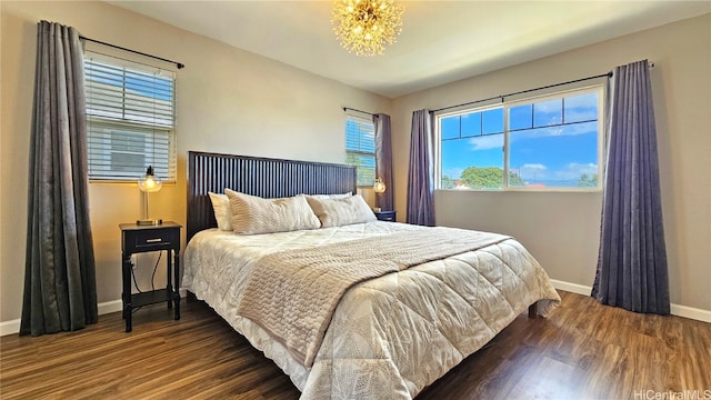 bedroom featuring a notable chandelier and dark hardwood / wood-style flooring