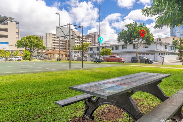 view of property's community featuring basketball court and a lawn