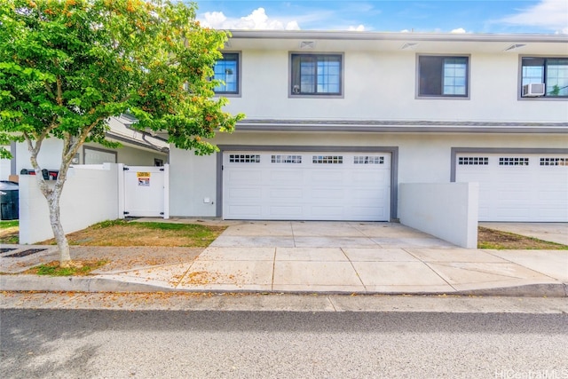 townhome / multi-family property featuring cooling unit and a garage