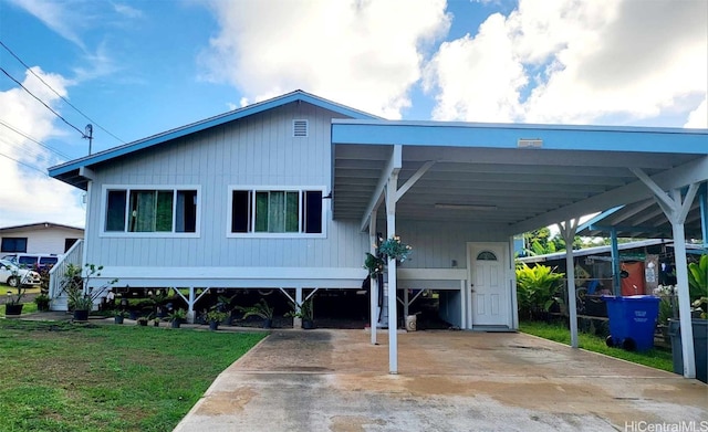 view of front of home with a carport and a front lawn