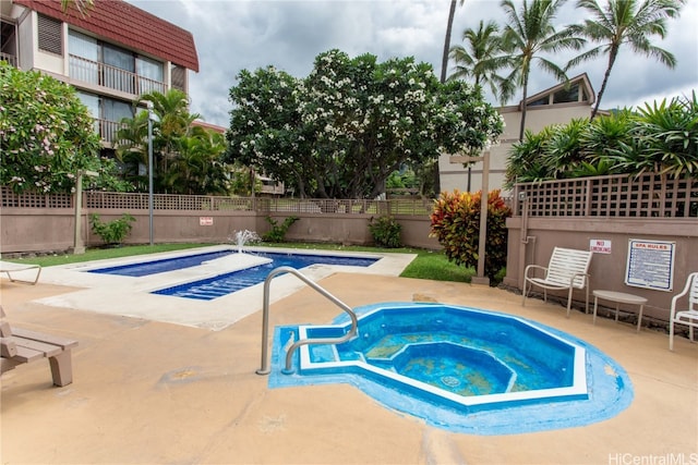 view of swimming pool with a patio and a hot tub