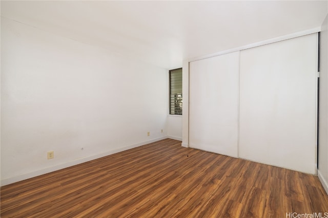 unfurnished bedroom featuring dark hardwood / wood-style floors and a closet