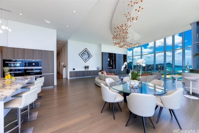 dining room with expansive windows, dark wood-type flooring, and a high ceiling