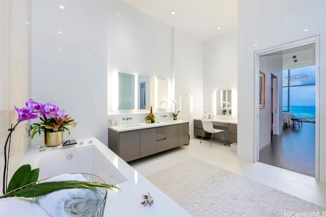 bathroom with tile patterned floors, vanity, and a bath