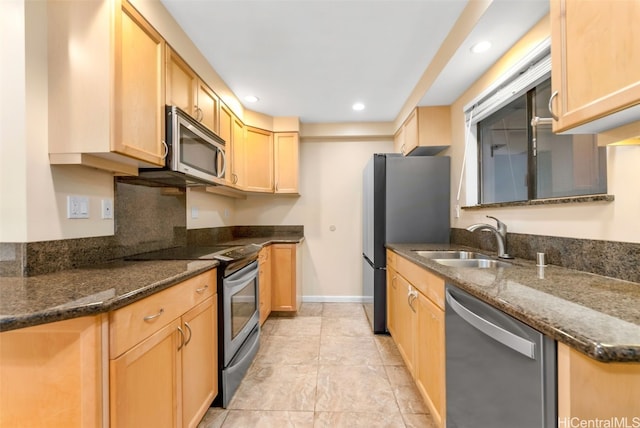 kitchen with light brown cabinetry, dark stone countertops, sink, and appliances with stainless steel finishes