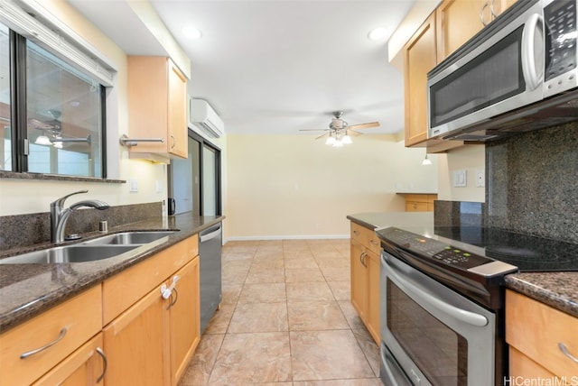 kitchen with a wall mounted AC, stainless steel appliances, dark stone counters, decorative backsplash, and sink