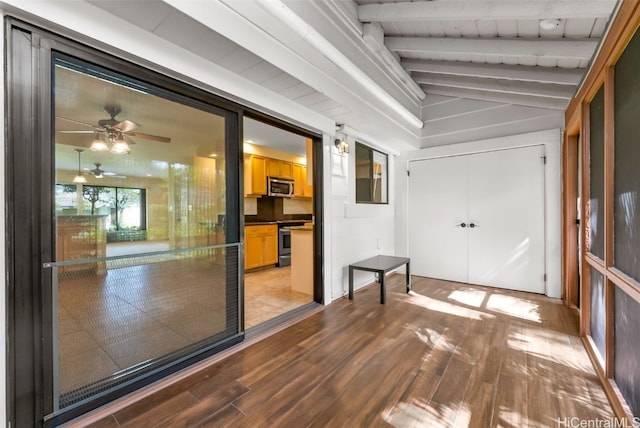 interior space with light hardwood / wood-style floors, vaulted ceiling with beams, and ceiling fan