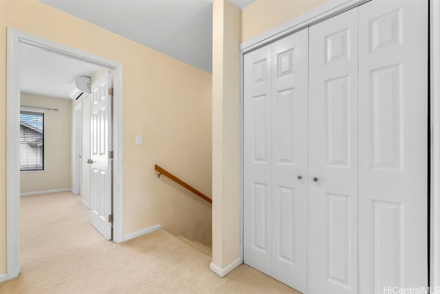 hall featuring a wall mounted air conditioner and light carpet